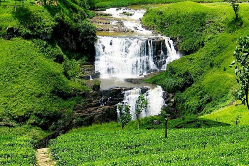 A waterfall cascading over lush green hills. 5