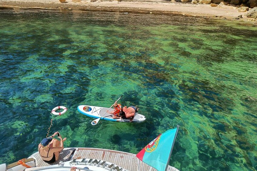 A person paddleboarding on clear water with a lifebuoy nearby. 4