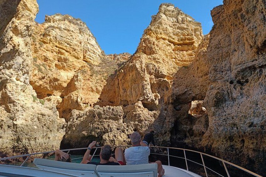 A boat navigating through a rocky canyon with tourists. 5