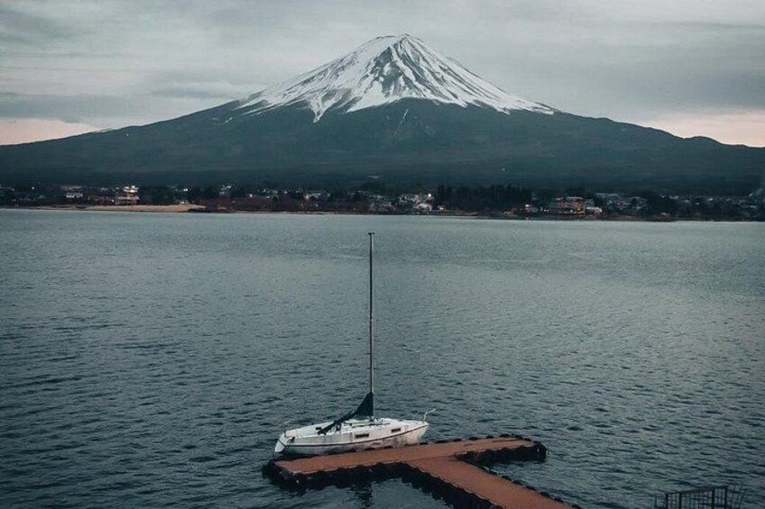 Una montaña nevada, un lago tranquilo y un bote pequeño en un muelle. 3