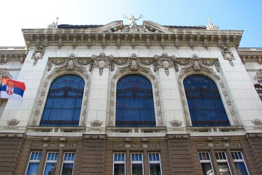 A building with ornate architectural details, including three large arched windows and decorative stonework. 4