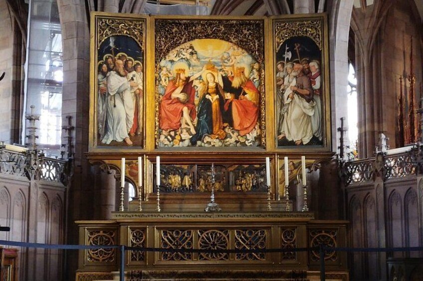 Interno di una chiesa con un grande trittico, un altare elaborato e architettura gotica. 2
