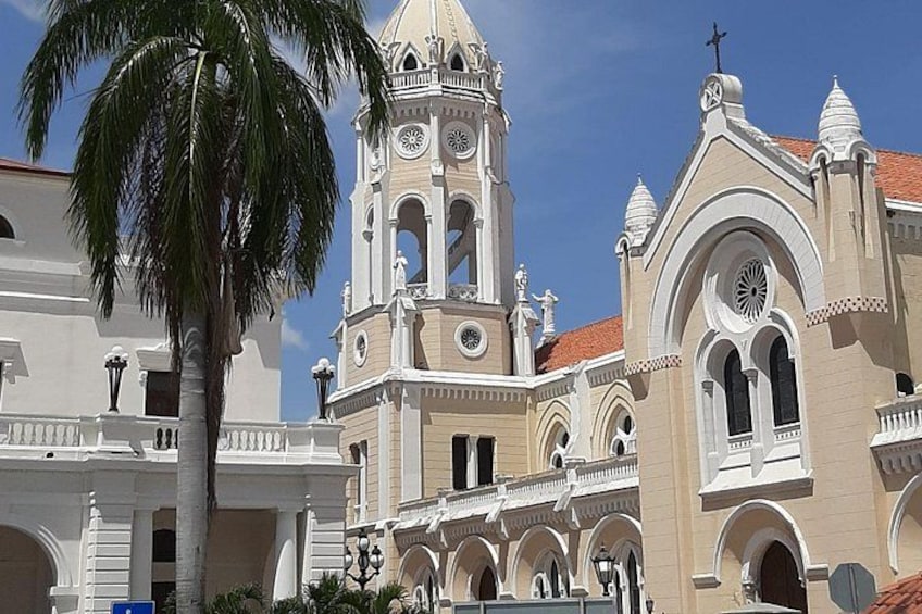 A historic building with a bell tower, arched windows, and a palm tree in the foreground. 4