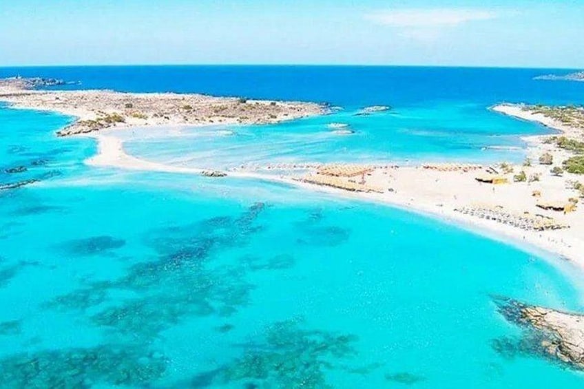 A coastal landscape with clear turquoise waters, sandy beaches, and rocky outcrops. 1