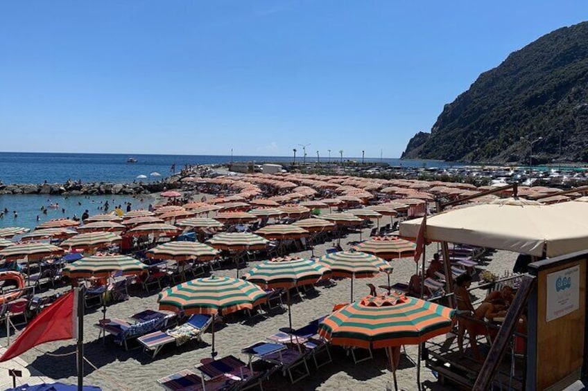 A crowded beach with numerous umbrellas and beach chairs. 2
