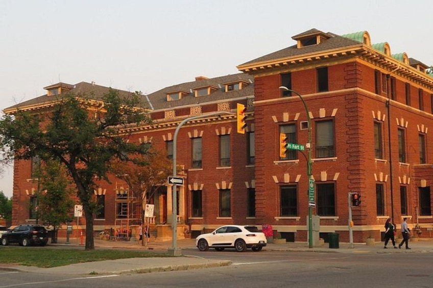 A red brick building with a green roof, a traffic light, and a street sign. 5