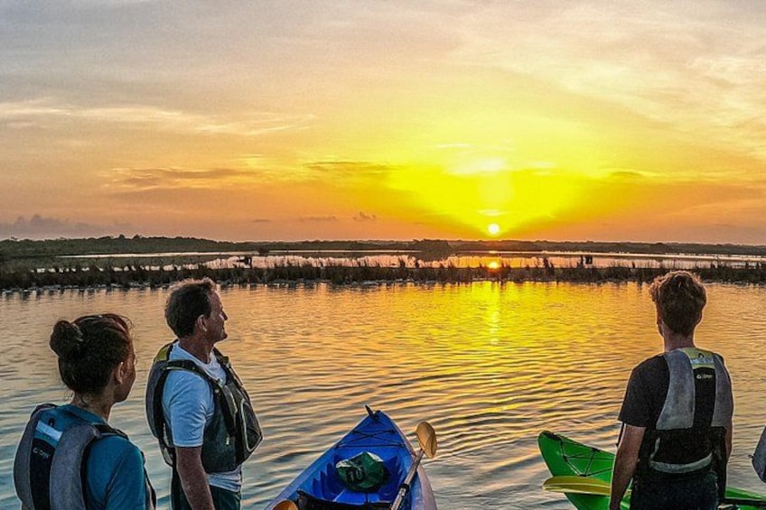 Tramonto su un'acqua calma con persone e kayak. 3