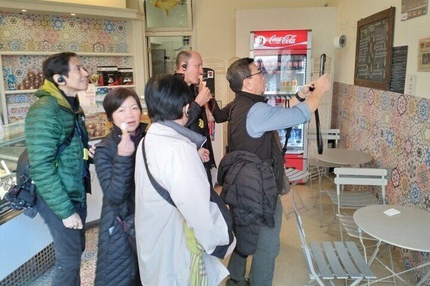 A group of people in a cafe with a Coca-Cola machine. 5