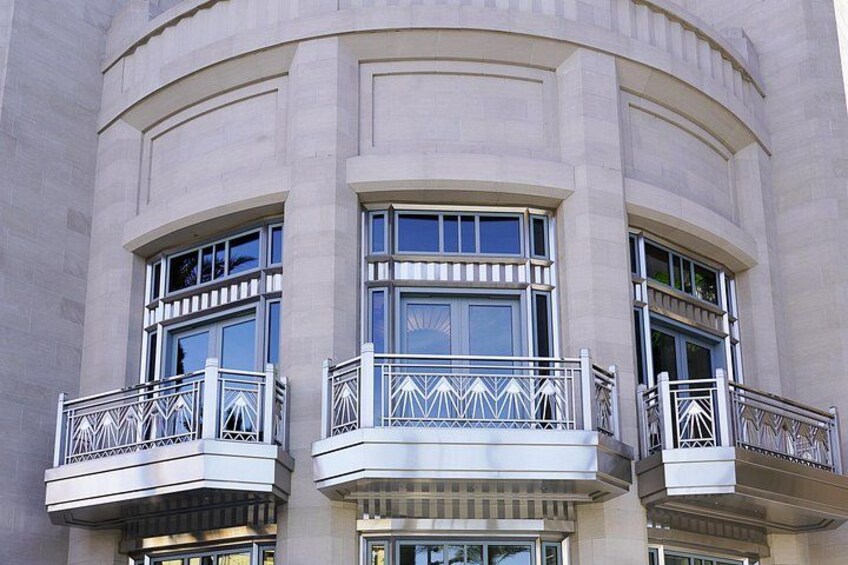 A building with three balconies, each with a metal railing and a geometric design. 2