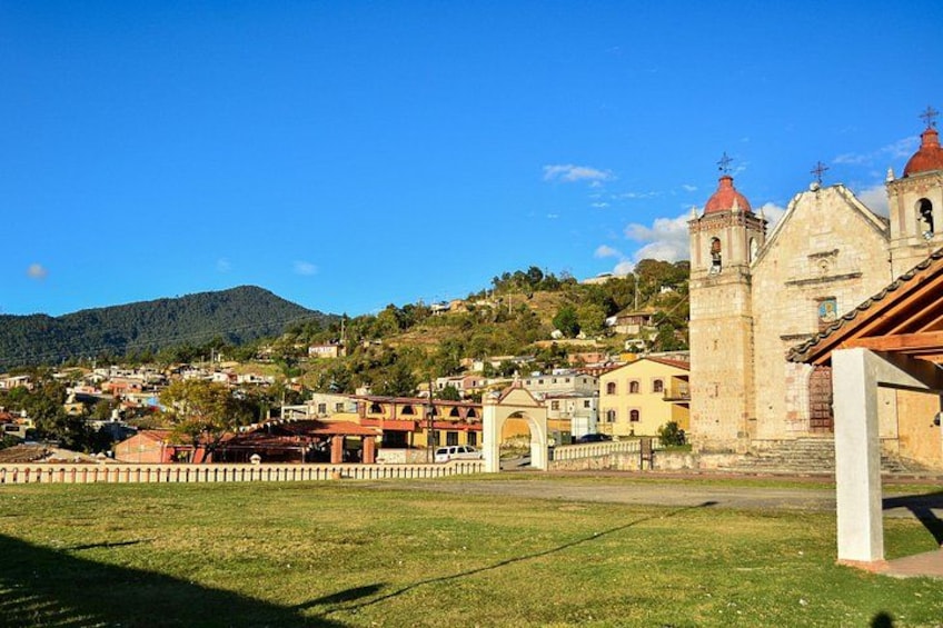 A town with a prominent church, a hill in the background, and a grassy area in the foreground. 3