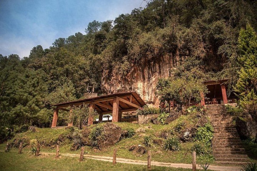 A wooden structure on a hillside with a staircase leading up to it. 4