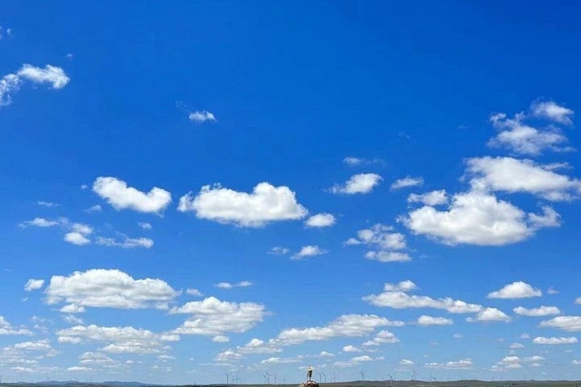 En klar, blå himmel med enstaka moln och ett flackt landskap. 3