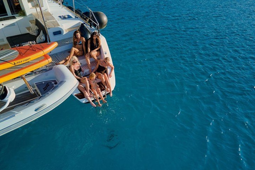 A group of people on a boat, water, and a shark. 2