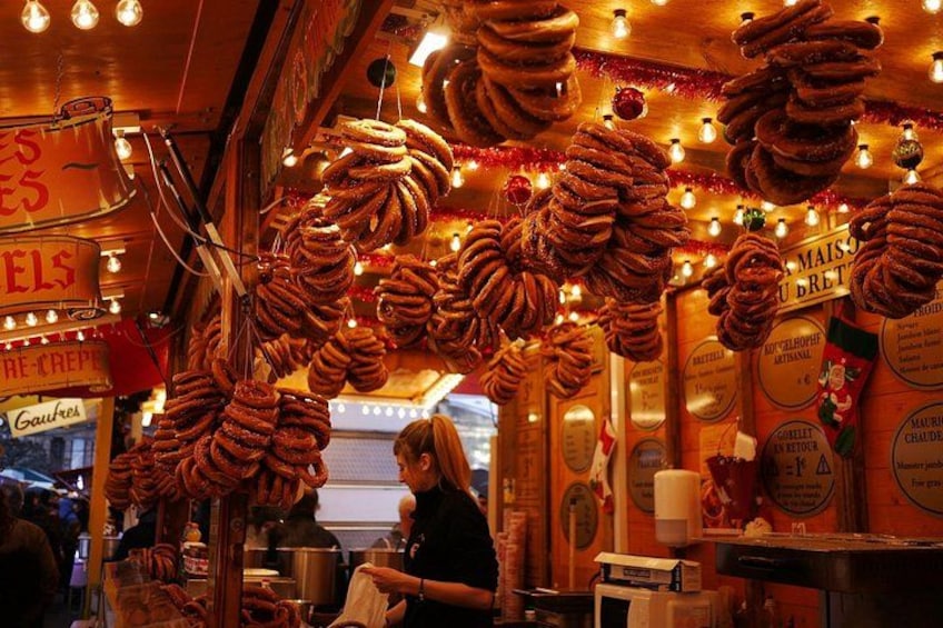 Un stand de nourriture de rue avec des bretzels suspendus et une femme assise au comptoir. 5