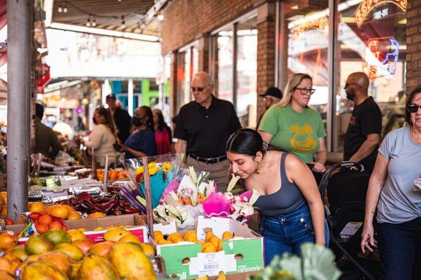 An outdoor market with people browsing and shopping. 1