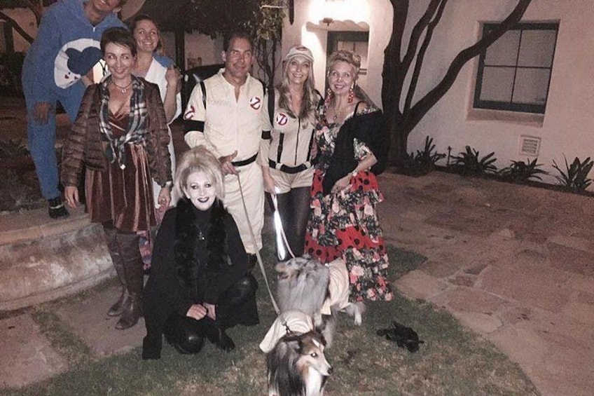 Un gruppo di persone in costume che posano con un cane in un cortile. 4