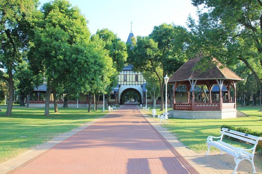A park with a gazebo, a pathway, and a building in the background. 4