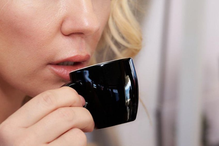 A person holding a black mug. 3