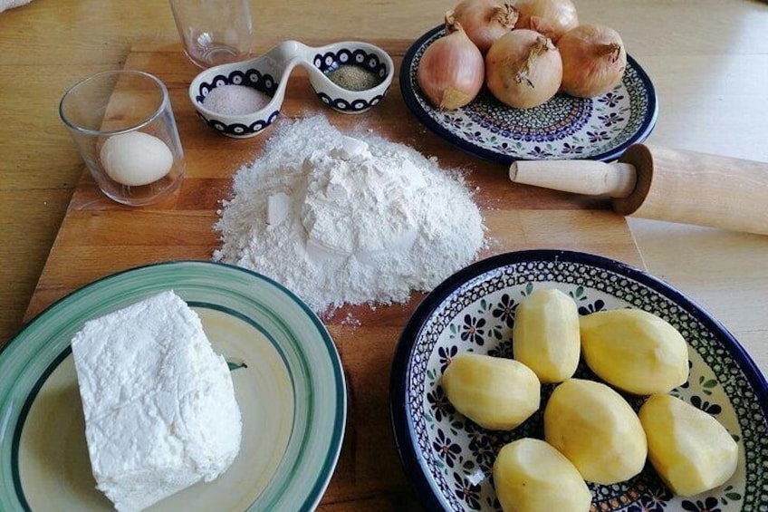 A kitchen counter with ingredients for baking, including flour, potatoes, onions, and a rolling pin. 3
