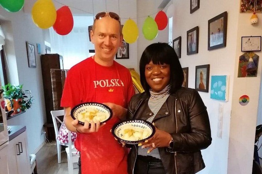 Two people holding plates with food, a red shirt with 'POLSKA' text, and a room decorated with balloons and pictures. 2