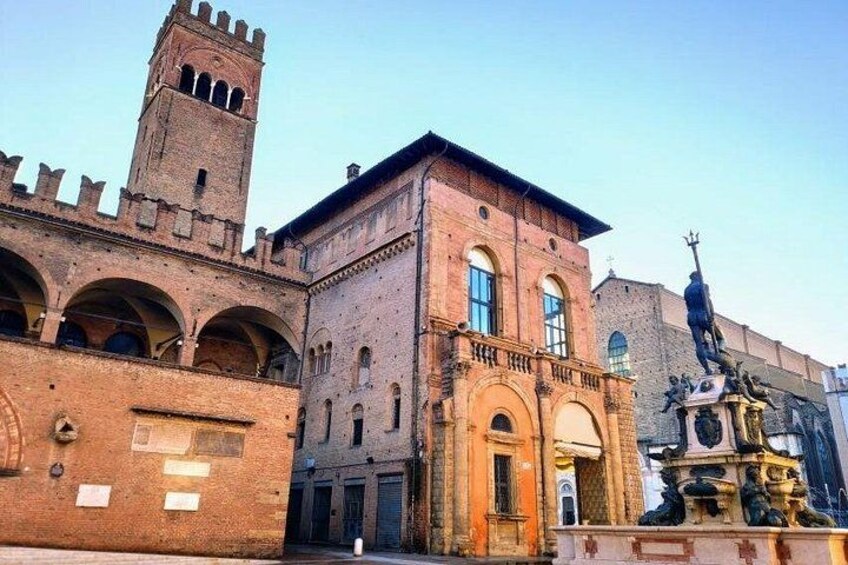 A historic building with a tower, arched windows, and a statue. 3