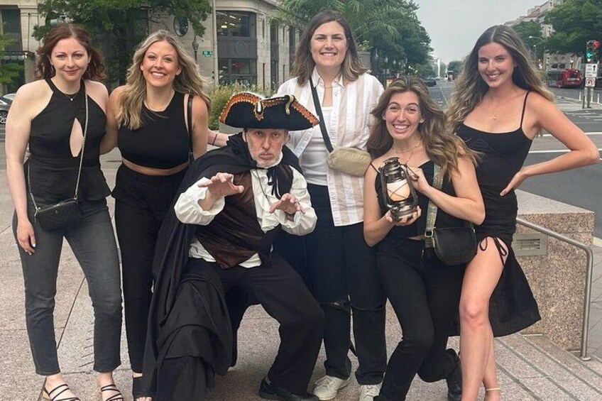 A group of people posing for a photo on a city street. 2