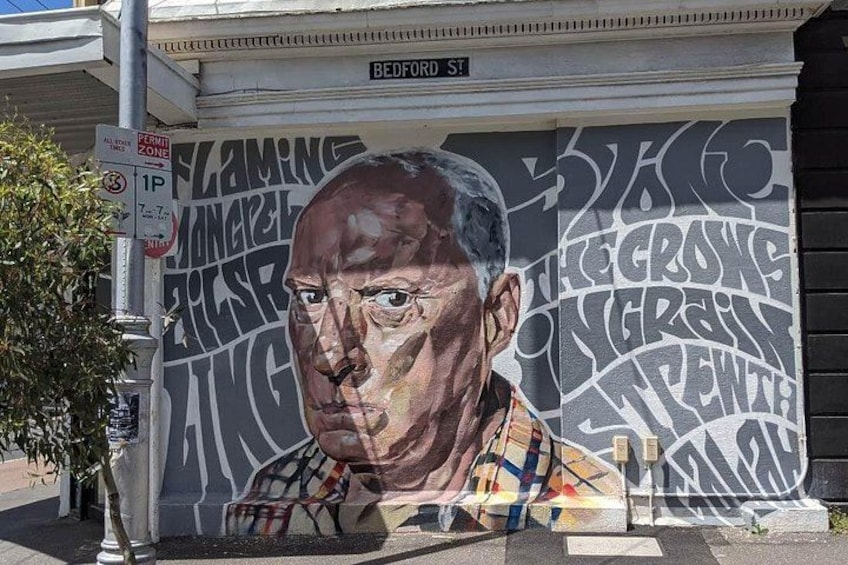 Un mural en un edificio con una señal de calle que dice 'BEDFORD ST'. 1