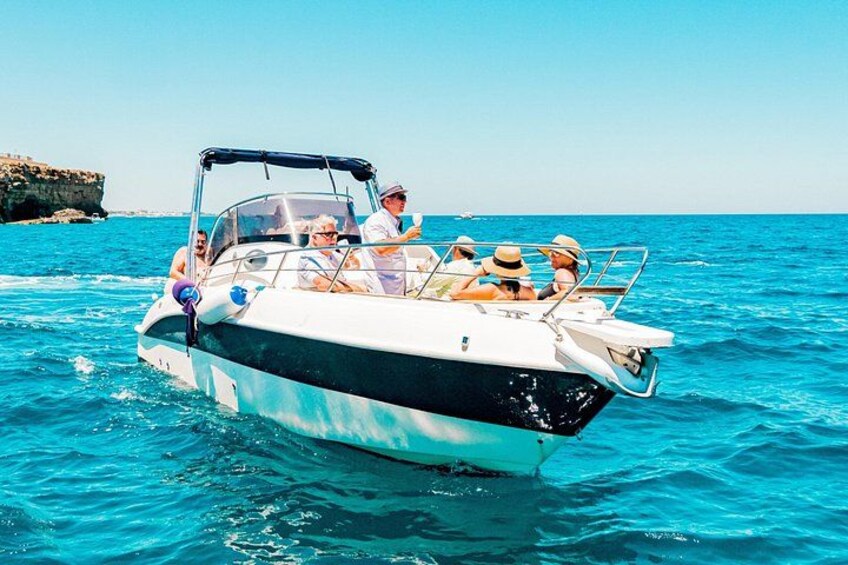 A boat with people on a clear blue sea. 2