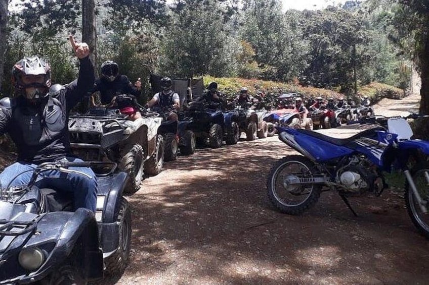 A group of people on ATVs in a forested area. 2