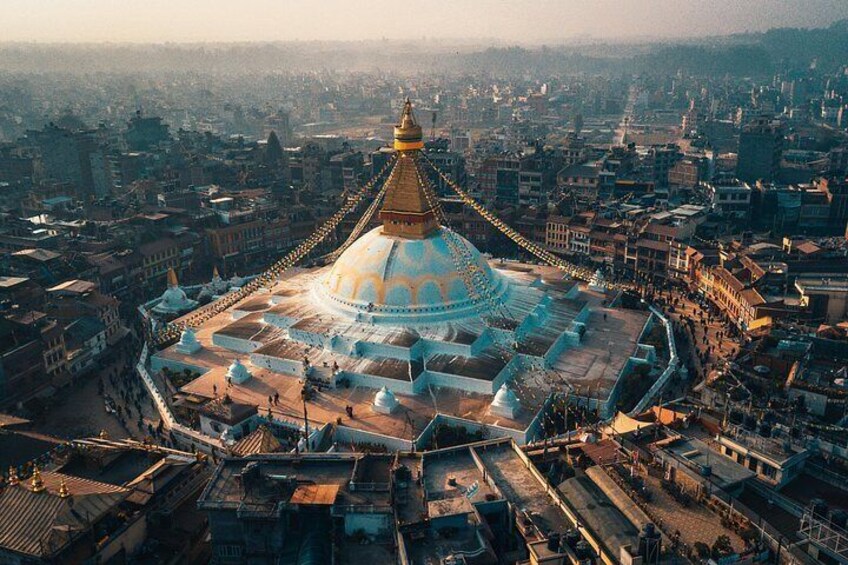 A large, domed building with a golden spire, surrounded by a densely packed urban area with various buildings and streets. 5