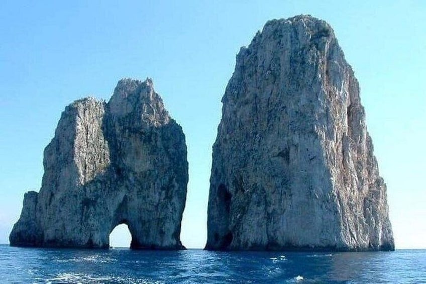 Two large rock formations with a natural archway between them. 3