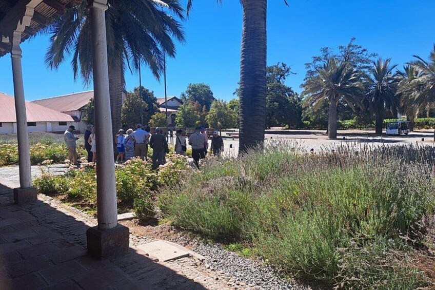 A group of people walking along a pathway with palm trees and a building in the background. 3