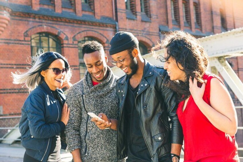 A group of people standing outdoors with a brick building in the background. 3