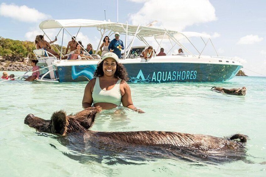 Ein Boot namens AQUASHORES mit Personen an Bord, eine Person, die mit einer Meeresschildkröte schwimmt, und eine weitere Meeresschildkröte im Wasser. 5