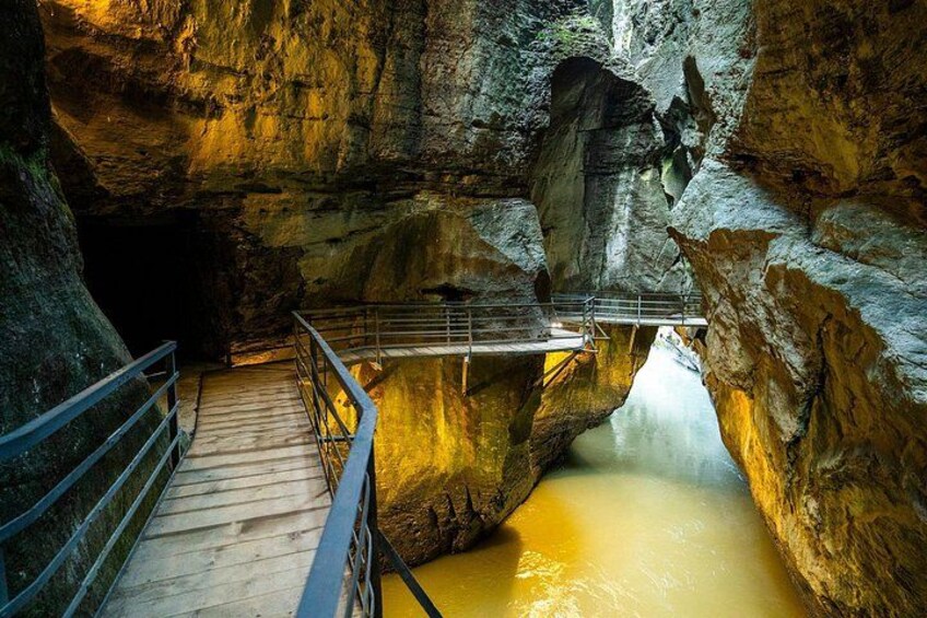 Une passerelle en bois surplombe une rivière dans une grotte rocheuse. 2