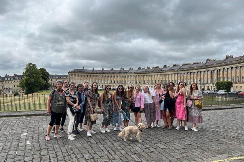 A group of people standing on a cobblestone street with historic buildings in the background. 3