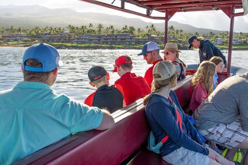 A group of people on a boat with a mountainous landscape in the background. 2
