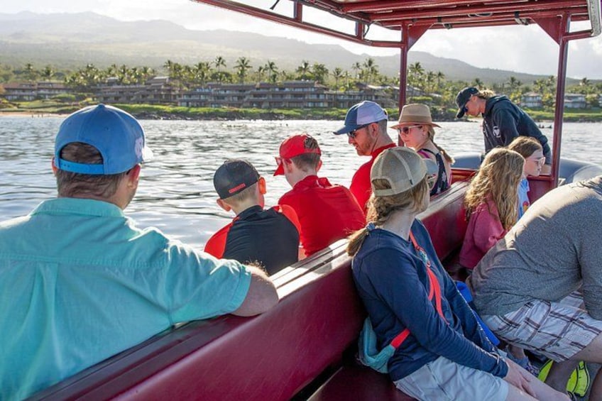 Un groupe de personnes se trouve sur un bateau, avec un paysage montagneux en arrière-plan. 2