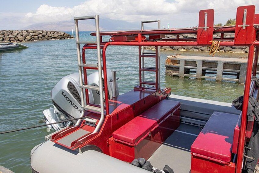 Een rode boot met een Honda buitenboordmotor, een trap en een steiger op de achtergrond. 5