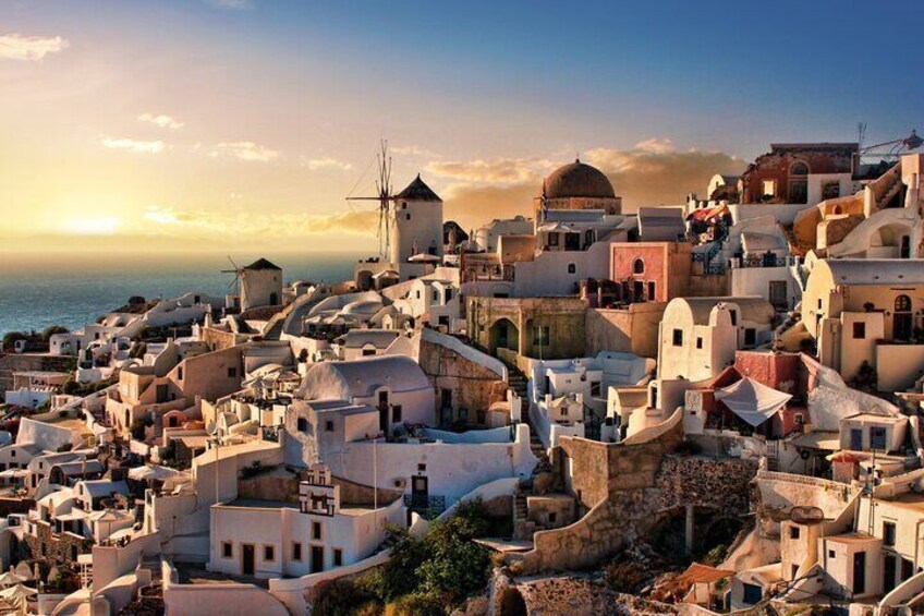 A coastal town with white-washed buildings, a windmill, and a dome structure. 5