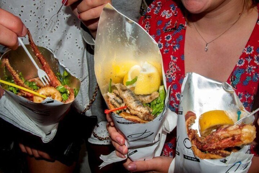 People holding food containers with seafood and lemon slices. 3