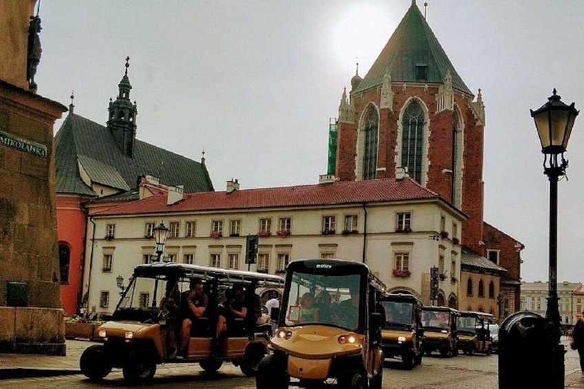 A street with vintage cars and a church in the background. 4