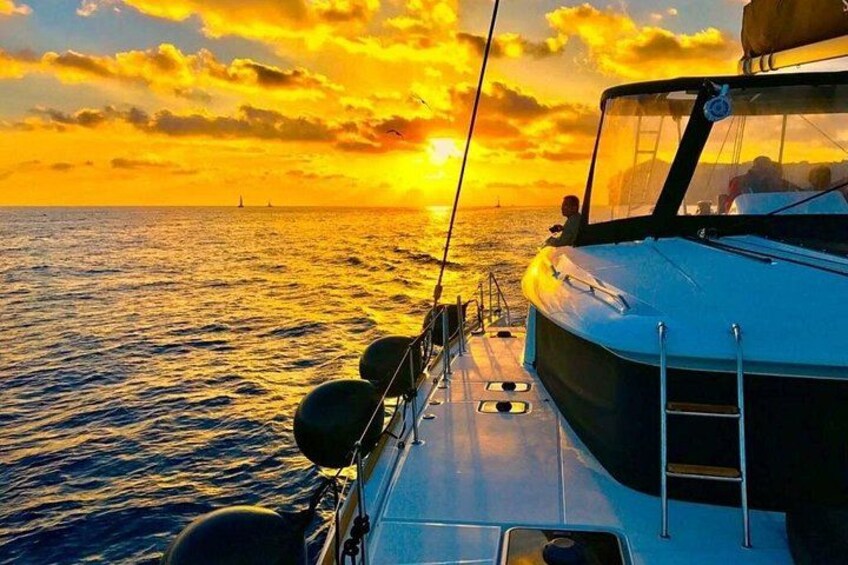 A boat on the water during sunset with a clear sky and a distant lighthouse. 5