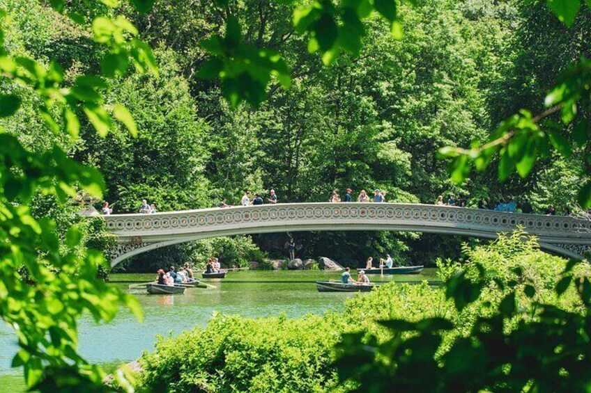 A stone bridge over a river with people on it and boats on the water. 2