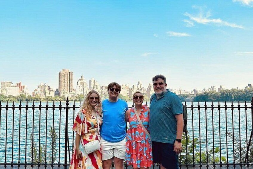 A group of people standing by a waterfront with a city skyline in the background. 4