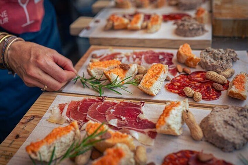 A variety of cured meats and cheeses on wooden boards. 1
