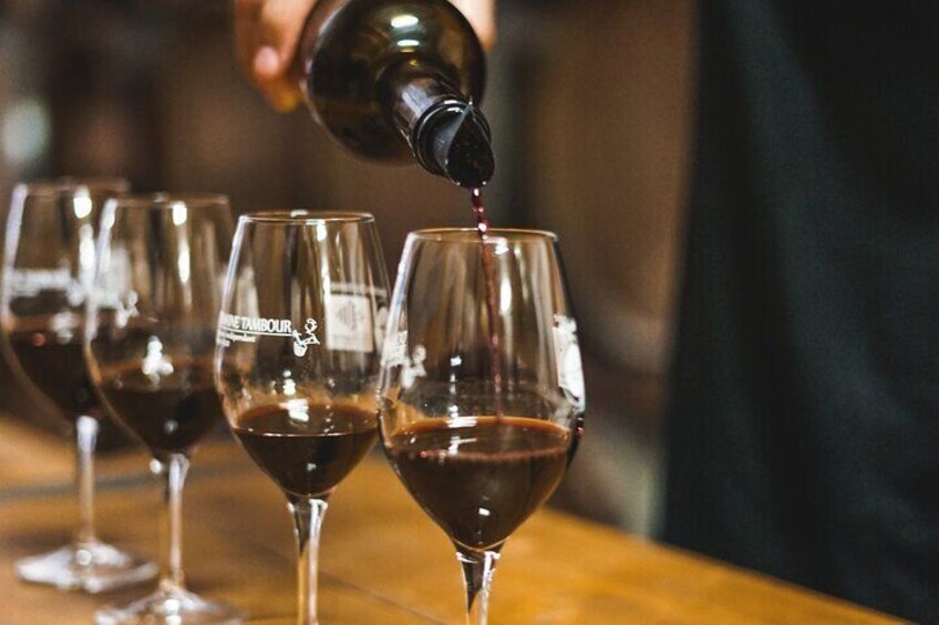 A person pouring wine into a glass. 5