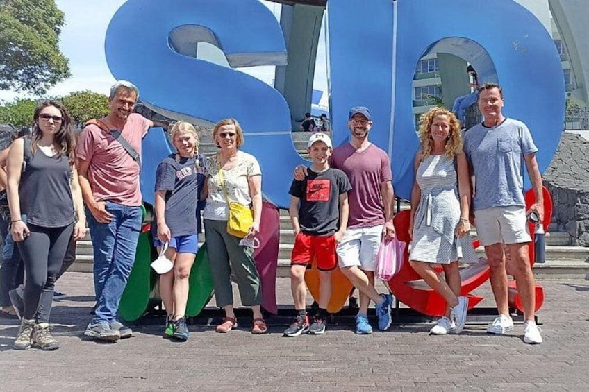 A group of people standing in front of a large blue sculpture. 5