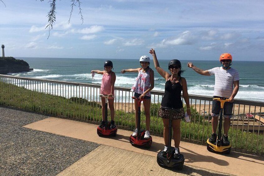 Mensen op hoverboards bij de zee, een reling en golven. 1