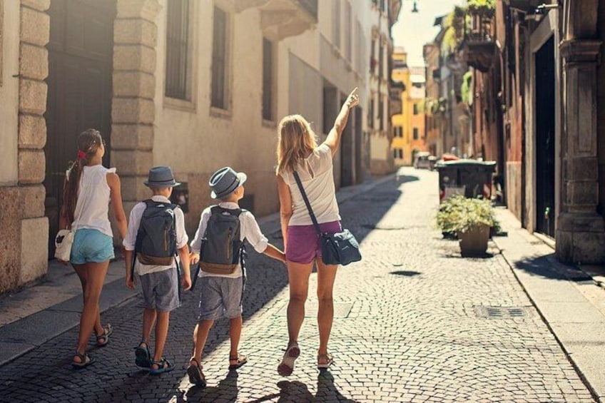 A group of people walking on a cobblestone street in a historic town. 2